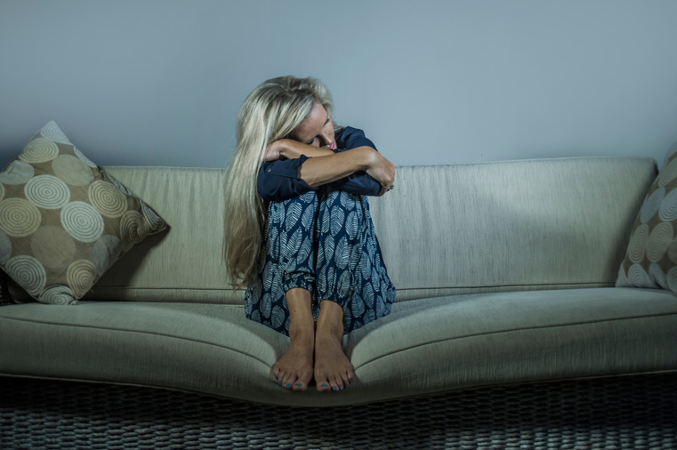 lifestyle dramatic portrait of attractive and sad woman feeling frustrated and anxious sitting at home sofa couch depressed suffering anxiety crisis and depression problem thoughtful and desperate
